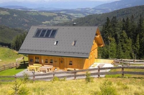a wooden house with a solar roof on a hill at Ferienhaus mit Wellnessbereich und Garten in Weitenbach