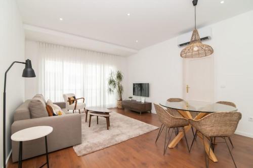 a living room with a couch and a table at Cozy Sea View Apartment near City and Airport in Ponta Delgada