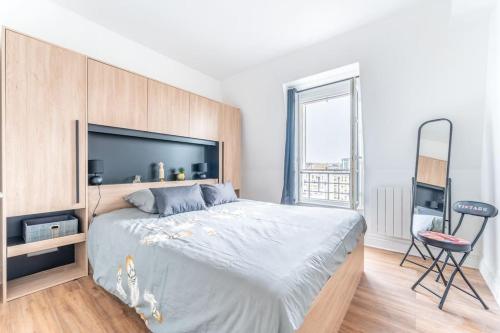 une chambre avec un grand lit et une chaise dans l'établissement Charmant Appartement Proche Tour Eiffel, à Paris