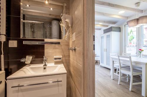 a kitchen with a sink and a table with chairs at Bedroom - domek nr 1 in Łeba