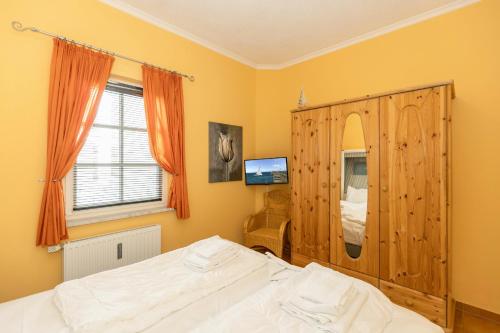 - une chambre avec un lit et une armoire en bois dans l'établissement Apartmenthaus Atlantik Apartmenthaus Atlantik 007, à Kühlungsborn