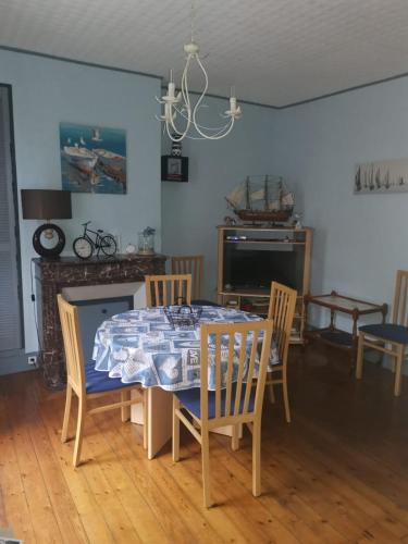 une salle à manger avec une table et des chaises et une télévision dans l'établissement Appartement avec Balcon au 1er étage Vue latérale Mer à 50 mètres de la plage à Mers les Bains., à Mers-les-Bains