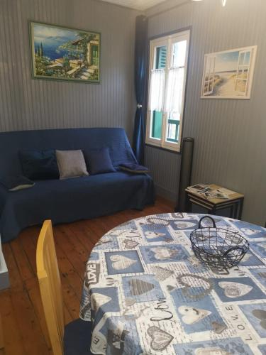 un salon avec un canapé bleu et une table dans l'établissement Appartement avec Balcon au 1er étage Vue latérale Mer à 50 mètres de la plage à Mers les Bains., à Mers-les-Bains