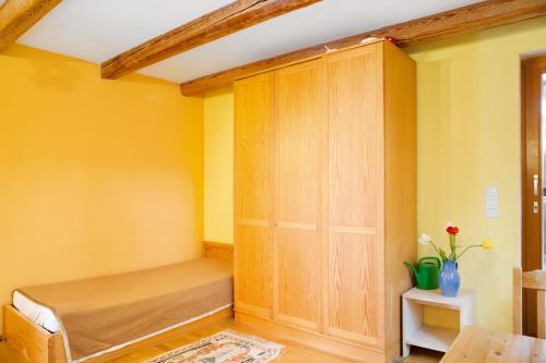 a bedroom with yellow walls and a wooden cabinet at Time to relax and enjoy nature in Grünwald