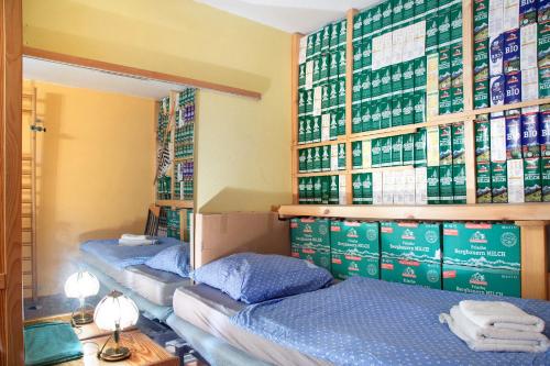 2 Betten in einem Zimmer mit Büchern an der Wand in der Unterkunft Milchtütenzimmer - Upcycling in Grünwald