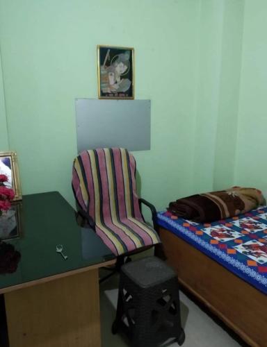 a bedroom with a desk and a chair next to a bed at S.S. GUEST HOUSE in Patna