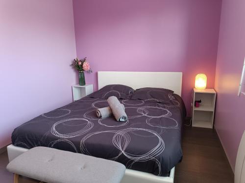 une chambre avec un grand lit aux murs violets dans l'établissement Appartement Cosy proche Mer, à Gouville-sur-Mer
