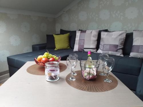einen Tisch mit Weingläsern und eine Schale Obst in der Unterkunft Appartement in Arrach mit Großem Balkon in Arrach