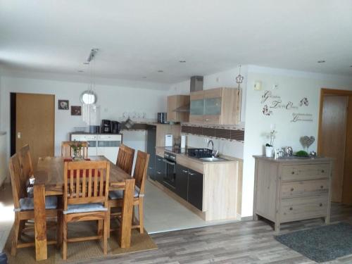 eine Küche mit einem Tisch und Stühlen sowie eine Küche mit einem Herd in der Unterkunft Appartement in Arrach mit Großem Balkon in Arrach