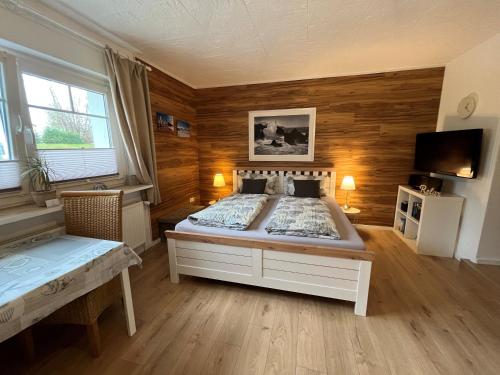 a bedroom with a large bed with wooden walls at Appartement 1 mit Küche und neuem Bad, frisch saniert in Friedrichskoog