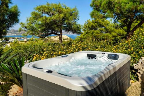 a hot tub in a garden with trees and flowers at Articiano Villa in Faliraki