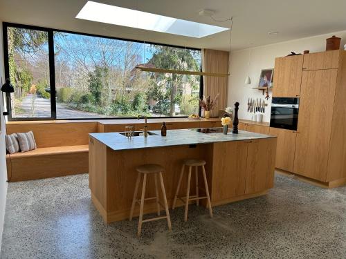 een keuken met een groot eiland met een aanrecht bij Modern bungalow in forest area in Nærum