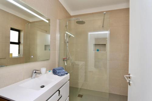 une salle de bain avec une douche avec un lavabo et une douche dans l'établissement Fig Villa- CleverDetails, Sleep 8, Pool, Children Playground, Ténis court, à Vilamoura