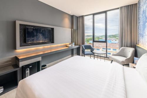een hotelkamer met een bed en een televisie bij ASTON Sorong Hotel & Conference Center in Sorong