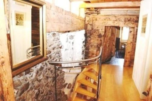 a room with a stone wall and a wooden floor at Das spezielle Ferienhaus Heidi - b48536 in Maienfeld