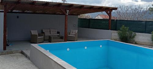 a swimming pool on a patio with a pergola at Apartments Calimero in Mostar