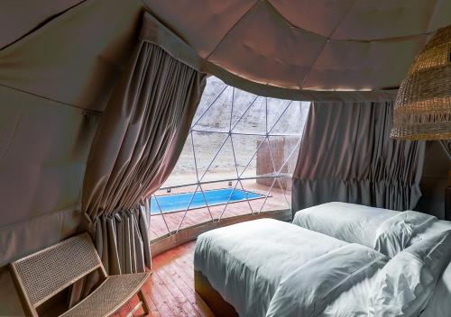 a bedroom with two beds and a large window at PAUSEAWAY at Tuwaiq House in Riyadh