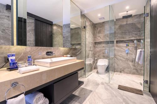 a bathroom with a sink and a shower at Aston Sorong Hotel & Conference Center in Sorong