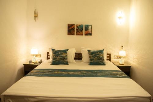- une chambre avec un lit avec deux lampes et deux tables dans l'établissement Majestic Villa, à Galle