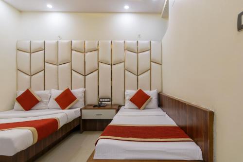um quarto de hotel com duas camas com almofadas vermelhas em The Price Hotels Main Bazar Pahar Ganj New Delhi em Nova Deli