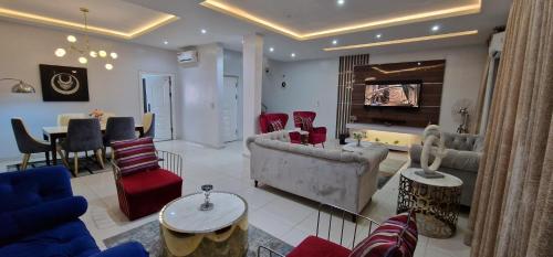 a living room with a couch and chairs and a table at Luxury 3-Bed house in gated estate with pool Lekki in Maiyegun