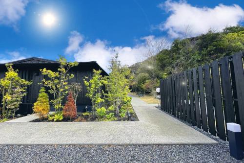 a fence in front of a house with trees at MOKU ISESHIMA ーl モク伊勢志摩 lー in Shima