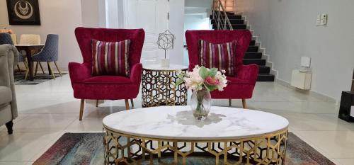 a living room with two chairs and a vase of flowers on a table at Luxury 3-Bed house in gated estate with pool Lekki in Maiyegun