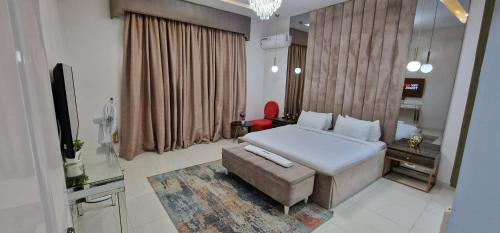 1 dormitorio con cama, sofá y TV en Luxury 3-Bed house in gated estate with pool Lekki, en Maiyegun