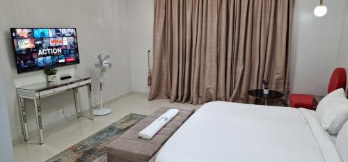 a hotel room with a bed and a flat screen tv at Luxury 3-Bed house in gated estate with pool Lekki in Maiyegun