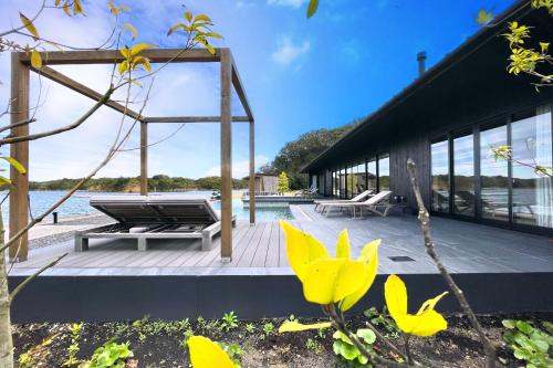 a house on the water with a wooden deck at MOKU ISESHIMA ーl モク伊勢志摩 lー in Shima