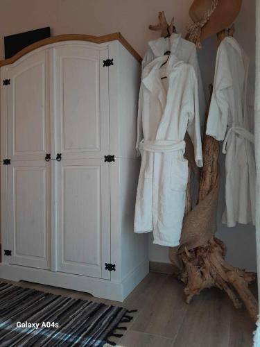 a room with white clothes hanging on a wall at Elaia Rest House Retreat in nature in Fréngaina