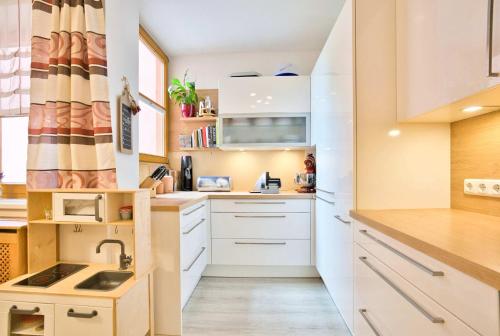 a kitchen with white cabinets and a sink at Etagenwohnung mit Garten in Vöcklabruck