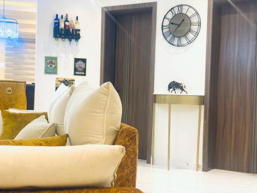 a living room with a couch and a clock on the wall at Beautiful 2 bed flat in much sought after estate in Moba