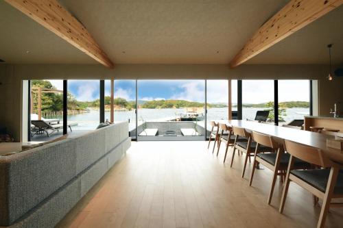 a dining room with a view of the water at MOKU ISESHIMA ーl モク伊勢志摩 lー in Shima