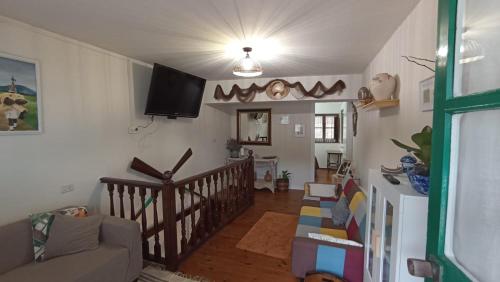 a living room with a couch and a tv on the wall at La Casina de MIRI in Tazones