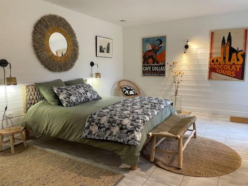 une chambre avec un lit et un miroir au mur dans l'établissement Casa Marcel déco sympa au calme dans la pinède, à La Tremblade