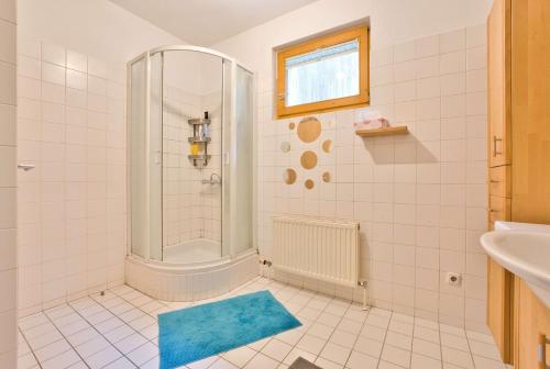 a bathroom with a shower and a blue rug at Etagenwohnung mit Garten in Vöcklabruck