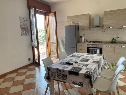 a kitchen with a table with chairs and a tablecloth on it at Torrione view apartment in Spilamberto