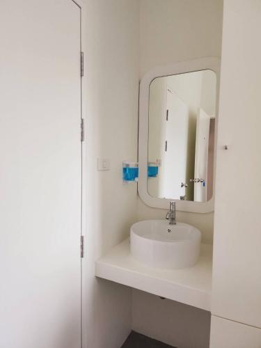 a white bathroom with a sink and a mirror at Line Bangkok Hostel in Bangkok