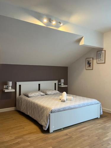 a bedroom with a bed with a white bed frame at Chez Néo in Doucier