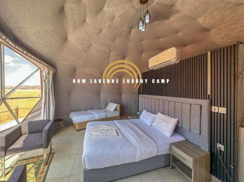 a bedroom with two beds in a room with a window at Rum Laverne Luxury Camp in Wadi Rum