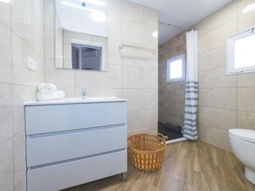ein Badezimmer mit einem Waschbecken, einem WC und einem Spiegel in der Unterkunft Cubo's Casa El Candil 6 PAX in Alhaurín el Grande