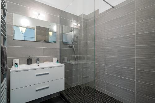 une salle de bain avec un lavabo et une douche en verre dans l'établissement Promenade des Anglais - 2 chambres - Jardin, à Nice