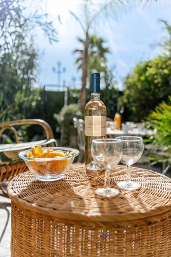une bouteille de vin et deux verres à vin sur une table dans l'établissement Promenade des Anglais - 2 chambres - Jardin, à Nice