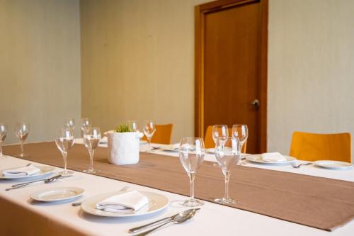 a long table with wine glasses and plates on it at Posadas de España Pinto in Pinto