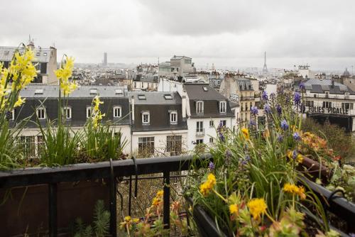 a view of a city from a balcony with flowers at Montmartre Gem in Paris