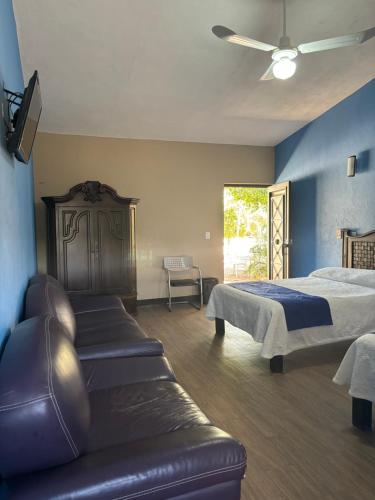 a bedroom with a bed and a couch in it at Frutos Hotel in Ameca