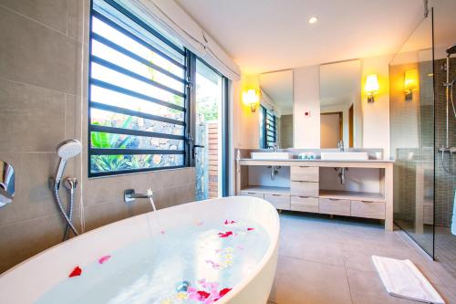 a bathroom with a bath tub and a sink at Marguery Villas in Rivière Noire