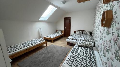 a room with three beds and a window at Bozsity Vendégház in Üllés