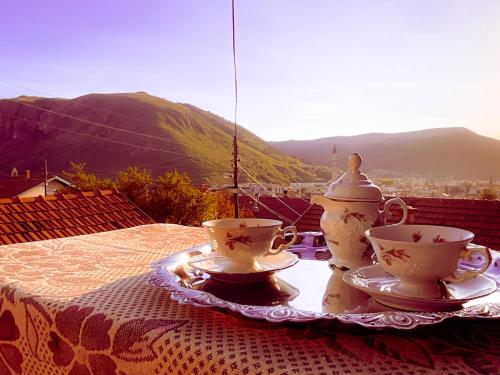 una mesa con dos tazas de té y una tetera en Balkan House, en Mostar